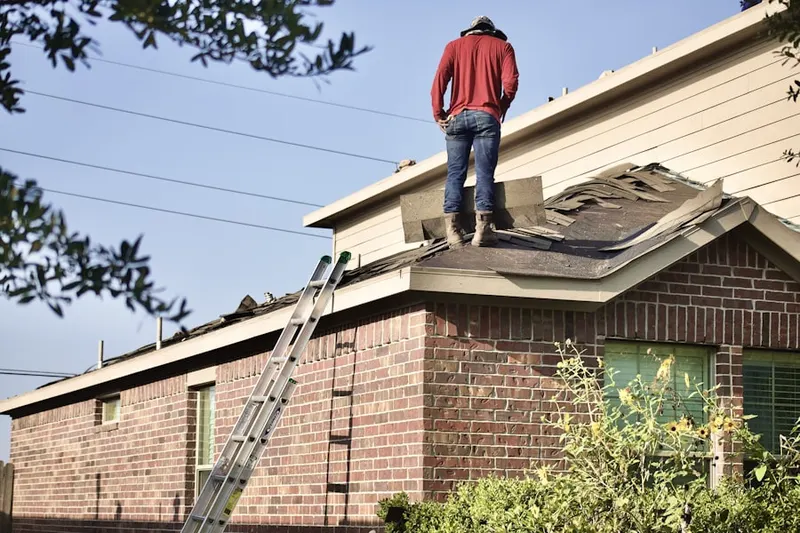 Professional roofer working on a residential roof in Island View